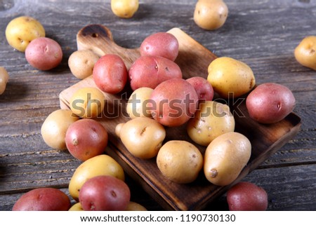Organic mixed baby potatoes on wooden cutting board Royalty-Free Stock Photo #1190730130