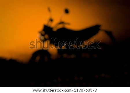 Blur the motorcycle silhouette and light the sky in the evening.