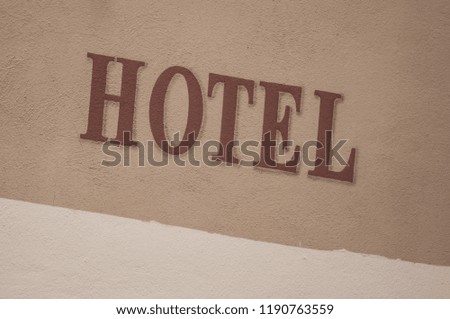 closeup of hotel signage on stoned wall