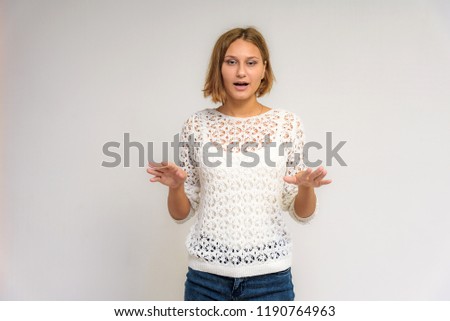 Portrait of a young beautiful girl on a white background. She is in front of the camera in different poses with different emotions.