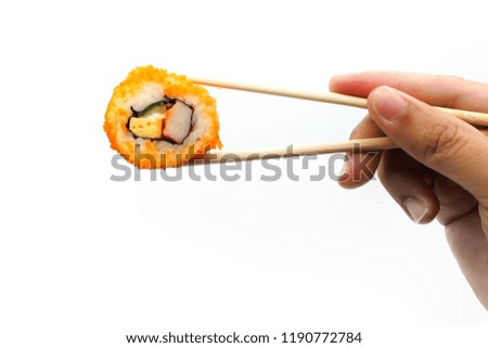 Holding California maki with chopsticks on white background.