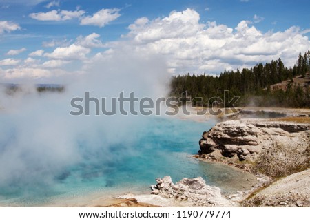 water evaporates from a hot spring with amazing light blue color in Yellowstone National park near grand prismatic pool, Royalty-Free Stock Photo #1190779774