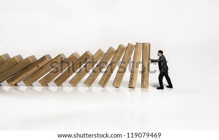 businessman is trying to prevent the falling Royalty-Free Stock Photo #119079469