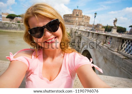 Woman taking selfie in front of St Angelo Castle in Rome, Italy