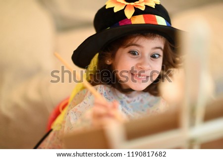 Happy little girl painting a picture at home