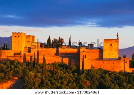 Granada, Spain. Aerial view of Alhambra Palace in Granada, Spain with Sierra Nevada mountains at the background. Sunset sky

