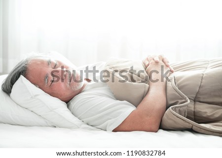 Senior man sleeping in bed. Old asian man sleeping comfortably in bed with curtain open. Senior lifesyle concept. Royalty-Free Stock Photo #1190832784