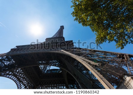 Eiffel tower framed in trees during sunny summer day,Paris,France