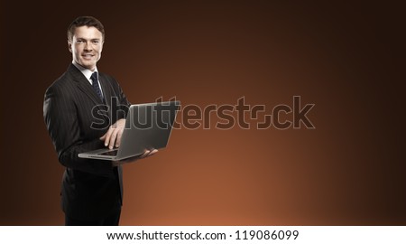 man standing with laptop in hand