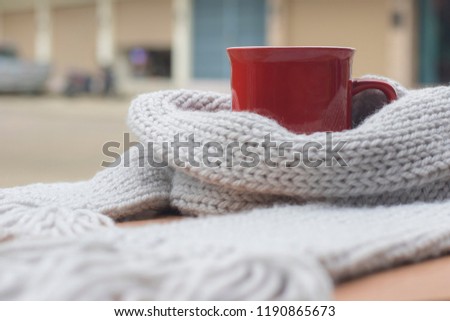 Modern holidays, Closeup picture of warm scarf with cup of hot coffee on wooden, About winter. Royalty-Free Stock Photo #1190865673