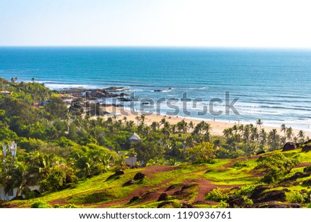 Evergreen natural beauty of Vagator beach from Chapora Fort located in Goa, India. Vagator Beach & Chapora Beach are two beautiful beaches in North Goa. Tropical beach in Goa with palm trees & ocean. Royalty-Free Stock Photo #1190936761