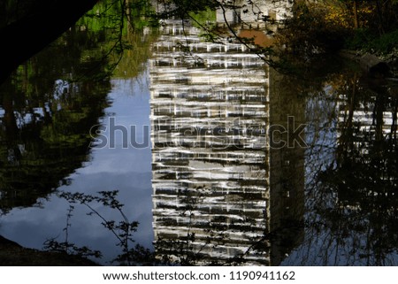 The reflection of the apartment building in the water. The lake in the park Mountsouris in Paris.