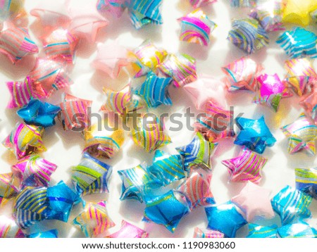 blurred abstract christmas background with colorful shining handmade origami stars
