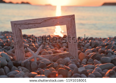 Foto frame in pebble with sun set 