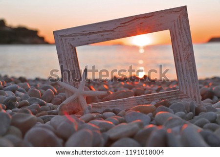 Foto frame in pebble with sun set 
