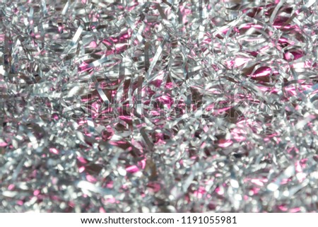 Background for beauty theme makeup cosmetics, crumpled uneven foil with Christmas tinsel flashing pink color