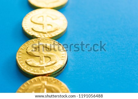 Gold dollar on a blue background. Concept of currencies.