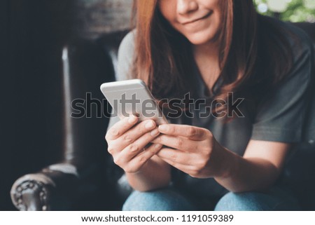 Closeup image of a beautiful asian woman holding , using and touching a smart phone