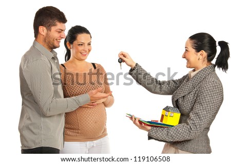 Agent giving house keys to a pregnant happy couple isolaed on white background