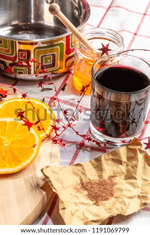 Preparation of hot mulled wine, ingredients in a saucepan, bright orange rings