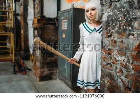 girl with baseball bat in abandoned factory