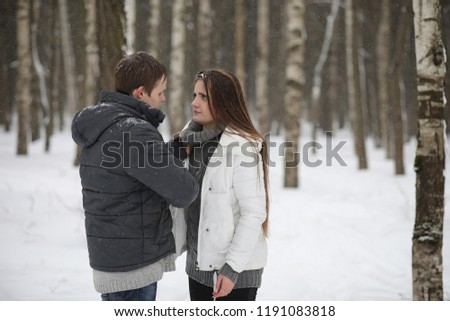 a pair of lovers on a date winter afternoon in a snow blizzard
