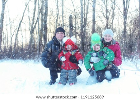 Family with children  in the park in winter snow blizzard