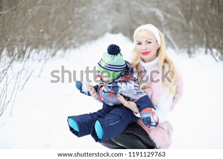 Young mother walks on a winter day with a baby in her arms
