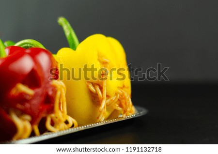 color stuffed peppers with scary cutout faces, halloween party food, fun
