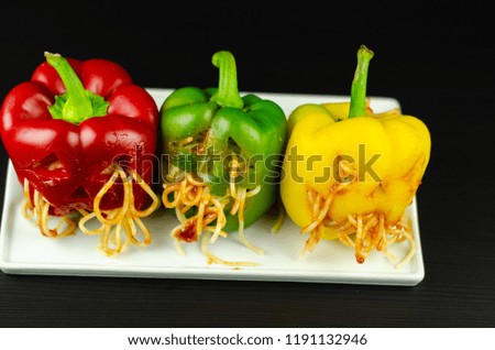 color stuffed peppers with scary cutout faces, halloween party food, fun