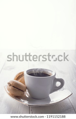 Tasty sweet macarons and coffee cup. Macaroons on white wooden background. Copy space