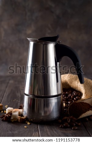 geyser coffee maker on the background of a bag of coffee and sugar grains on a dark wooden background, copy space