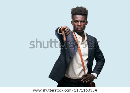 young black businessman with a dissenting, serious, stern expression, with thumbs down in disapproval. Royalty-Free Stock Photo #1191163354