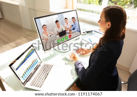 Side View Of A Young Businesswoman Videoconferencing With Her Colleagues On Computer Royalty-Free Stock Photo #1191174067