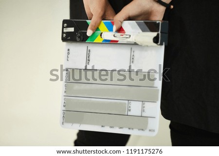 A clapper for shooting movies, A person's hands, is going to write on the flapper
