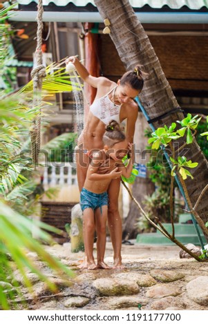Mother with her son are taking shower