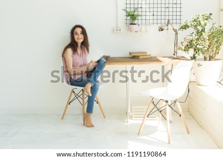 Technology and people concept - Young beautiful woman sitting at the white table with digital tablet