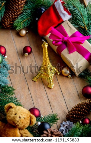 Christmas decoration and Eiffel tower with pine cones and branch on wooden background