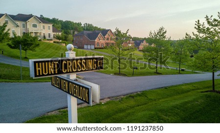 Panoramic real estate aerial view of Maryland single family homes, country houses with golden street sign at sunset