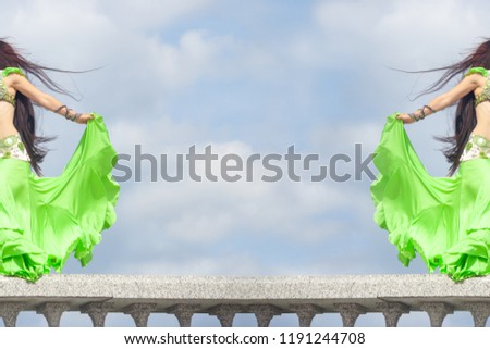 backdrop, background for posting information about belly dancing. The skirt and hair of the girl, a dancer, develops in the wind. The girl is symmetrically depicted at the edges of the frame.