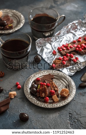 Cups of coffee with chocolate on a stone background.
