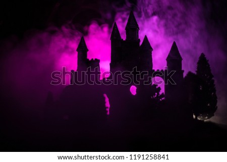 Mysterious medieval castle in a misty full moon. Abandoned gothic style old castle at night. Selective focus