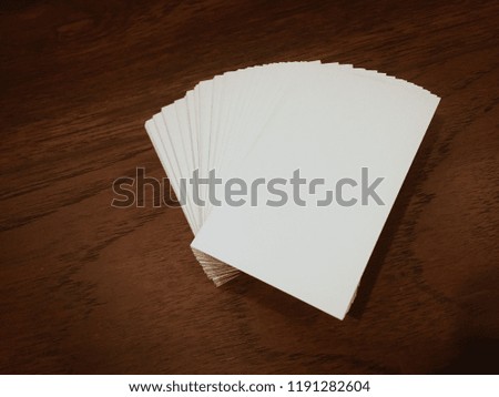 Stack of white cards on wooden table.