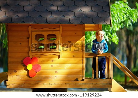 cute baby boy playing in tree house, sunny outdoor
