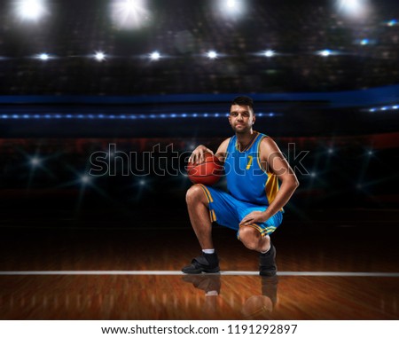 basketball player in blue uniform sitting on basketball court
