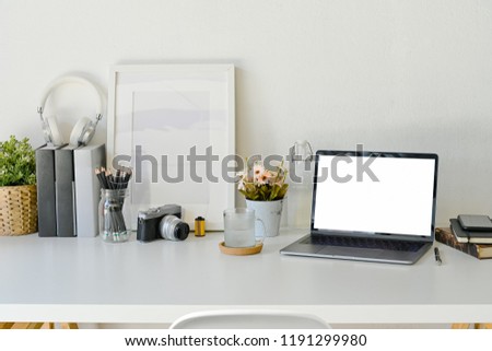 Creative workspace mock up laptop blank screen in modern home office interior with office supplies on white wooden desk,