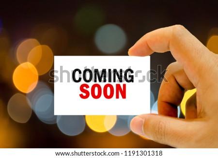 coming soon written on business car man hand holding