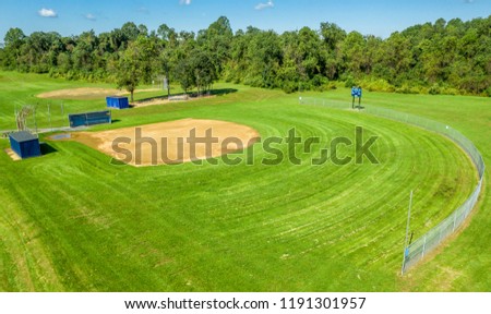 High school softball field with green grass and blue sky