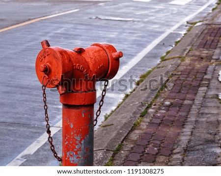 old red fire hydrant on street after raining