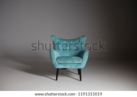 Upholstered Teal Wingback Chair with Wood Legs on White Background with Shadows. Modern Armchair with Wings and Casters on Front Legs. Interior Furniture. Fabric Arm Chair with Armrests Royalty-Free Stock Photo #1191315019